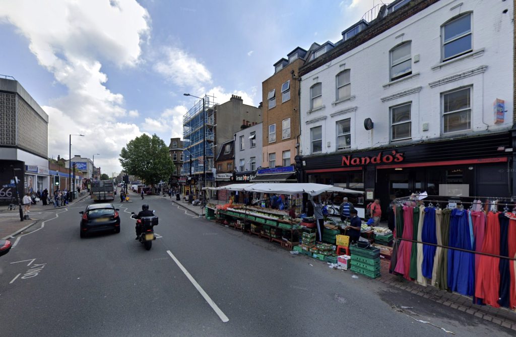 Woman scolded by firefighter after walking under unstable scaffolding damaged by Storm Bert in London. Reckless act sparks outrage and disbelief from locals and online viewers.