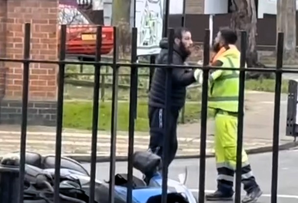 Two men brawl in a dramatic road rage clash on a busy London street, complete with a martial arts move, a downed moped, and chaos likened to a real-life *EastEnders* scene.