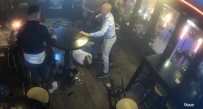 A brutal bar brawl in Helmond, Netherlands, saw a woman kicked in the head as chaos erupted. Three men were arrested as shocking CCTV footage captured the fight.