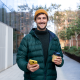 man green coat yellow hat phone coffee