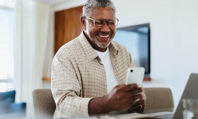 man smiles mobile phone desk modern setting