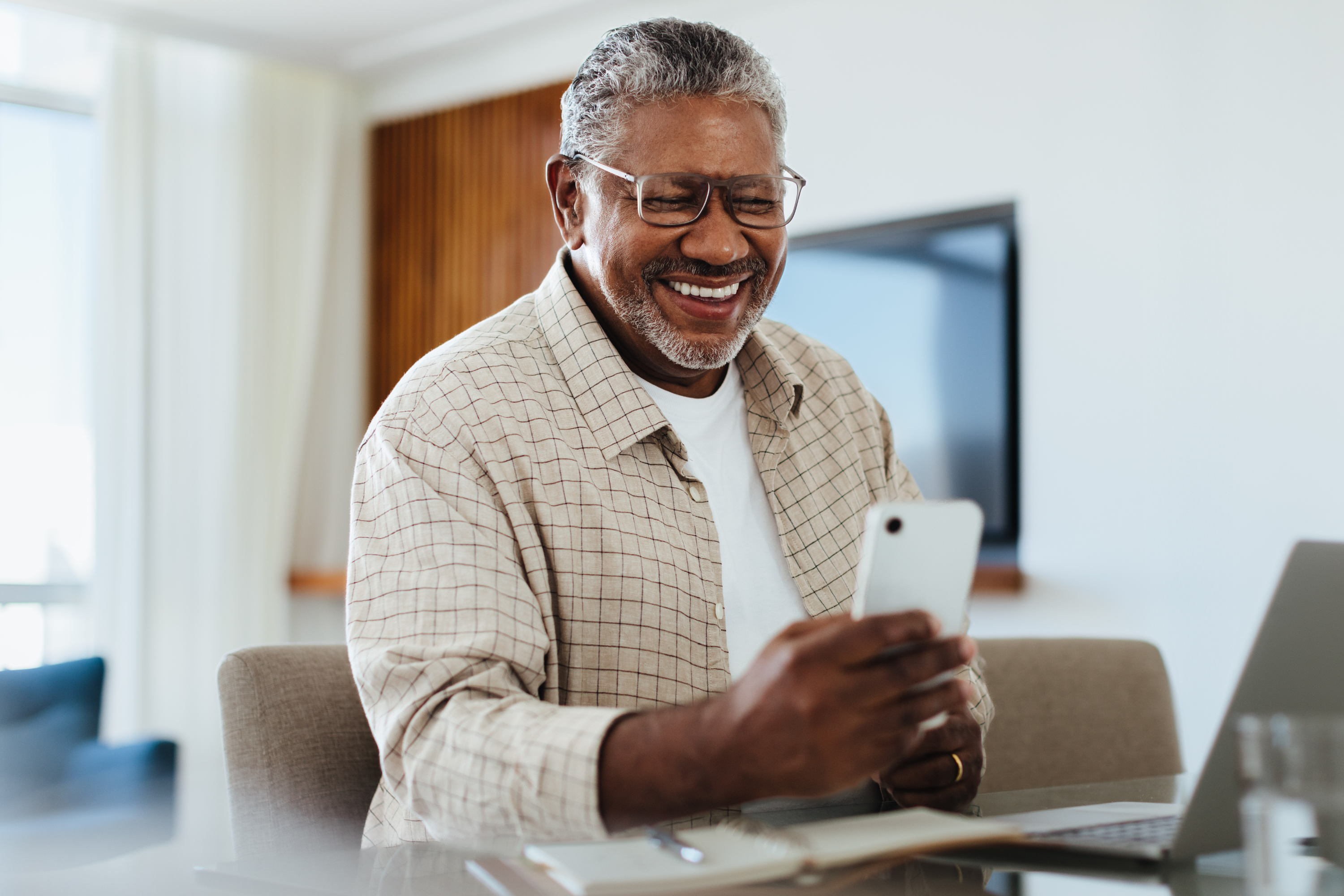 man smiles mobile phone desk modern setting