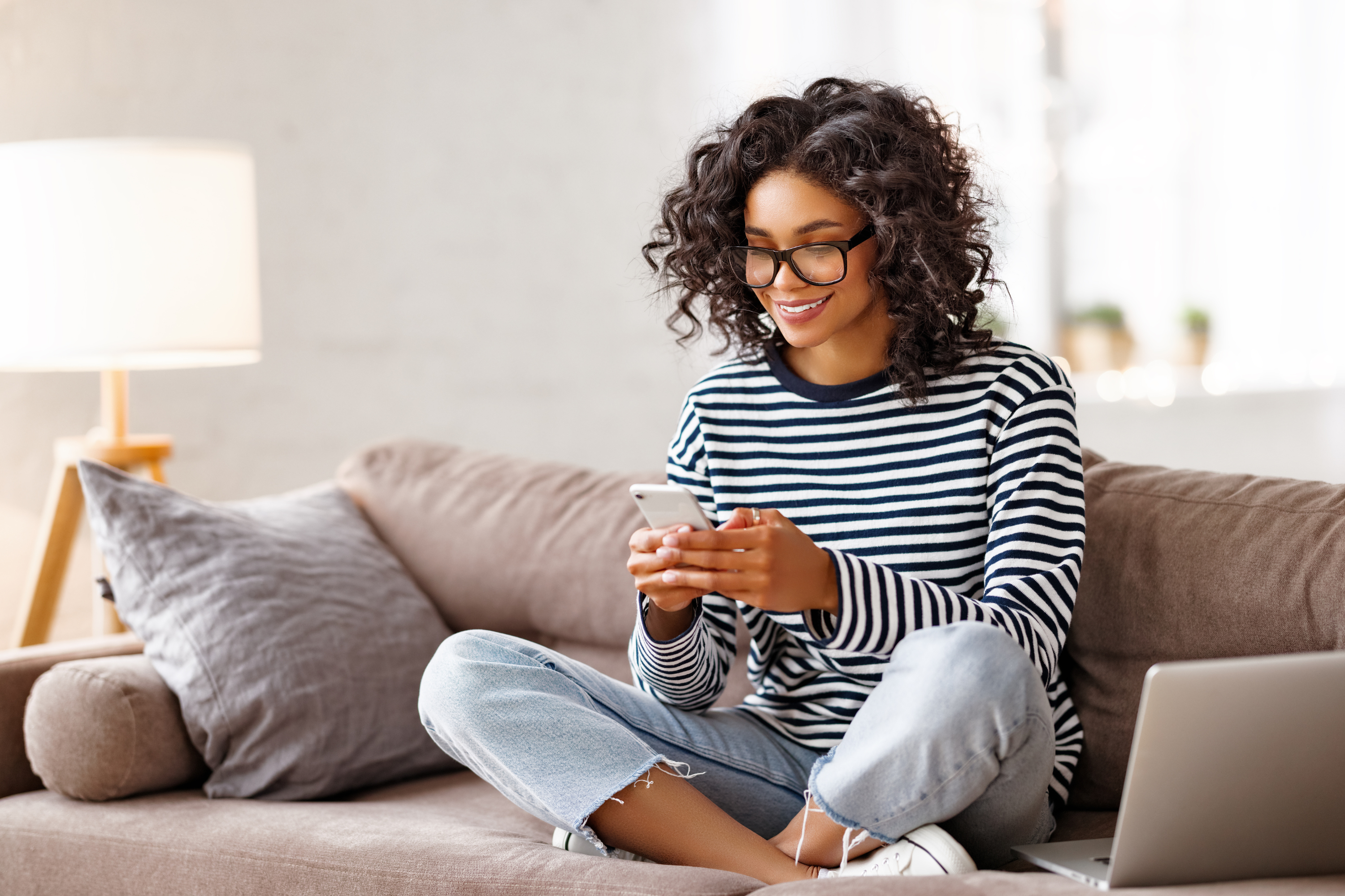 woman glasses striped shirt jeans phone laptop