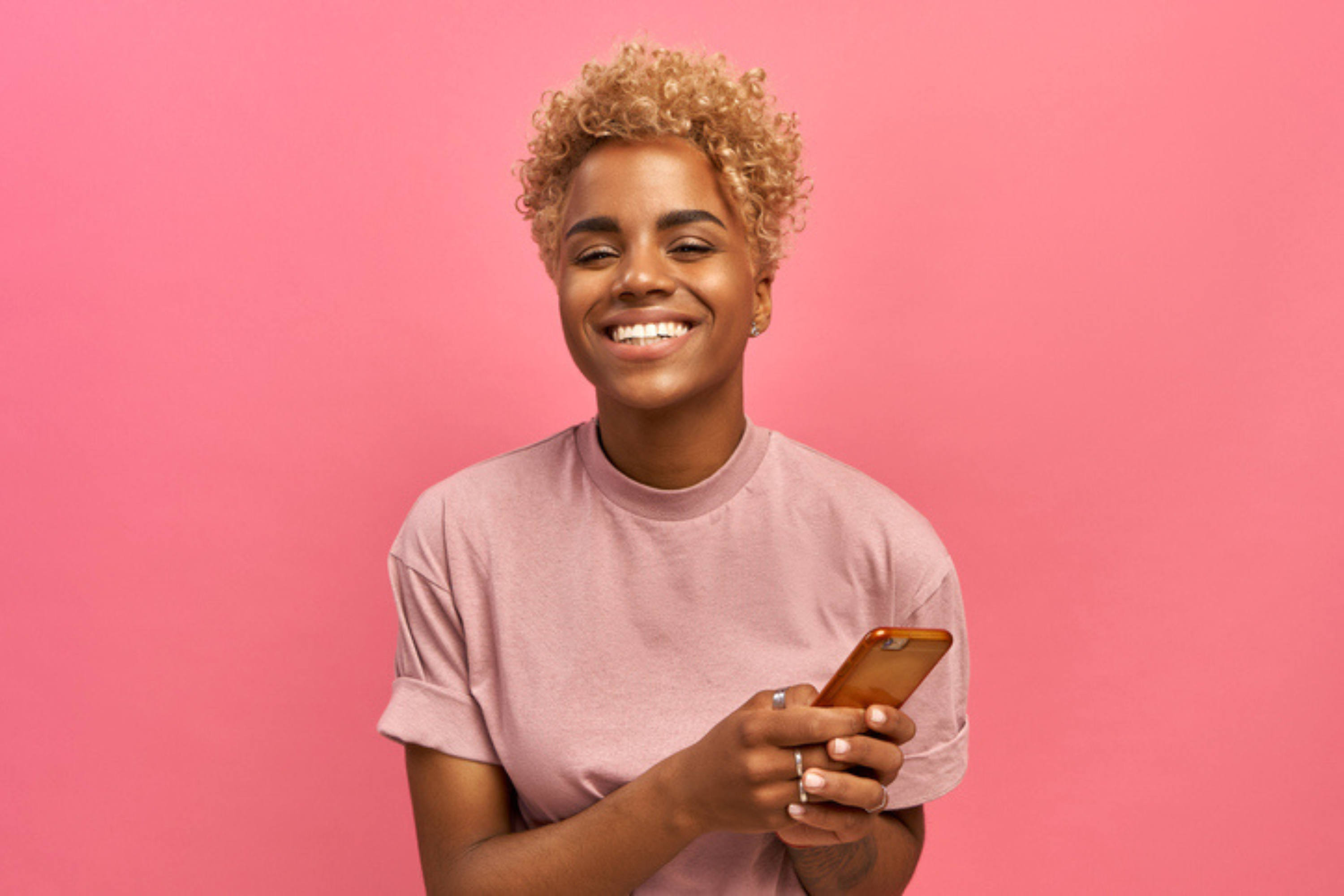 woman pink shirt pink background mobile phone