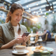 woman smartphone coffee croissant terrace coffee shop