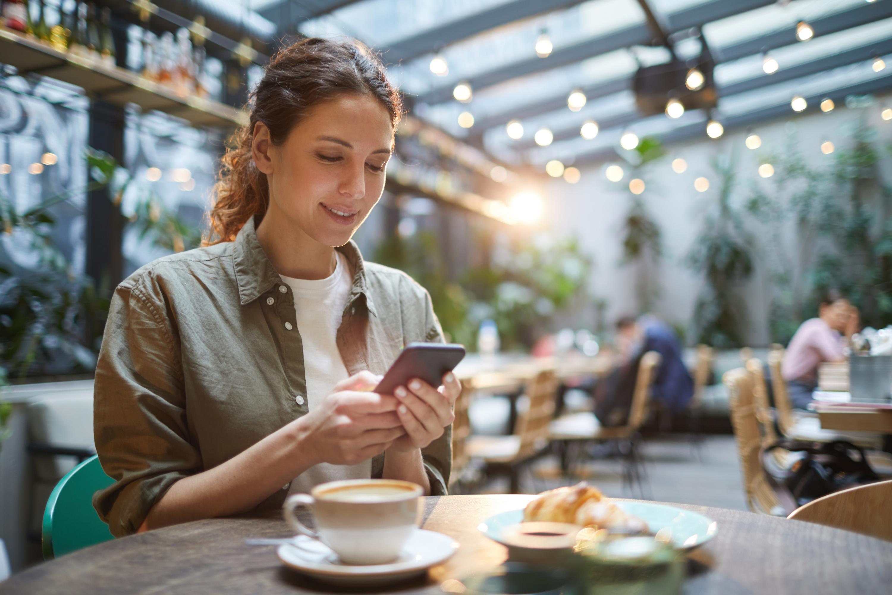 woman smartphone coffee croissant terrace coffee shop