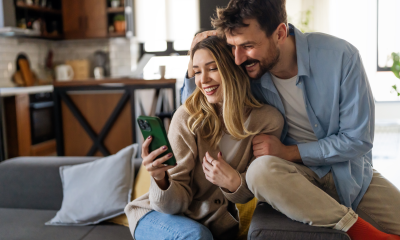 cozy couple embraces mobile phone couch home