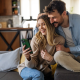 cozy couple embraces mobile phone couch home