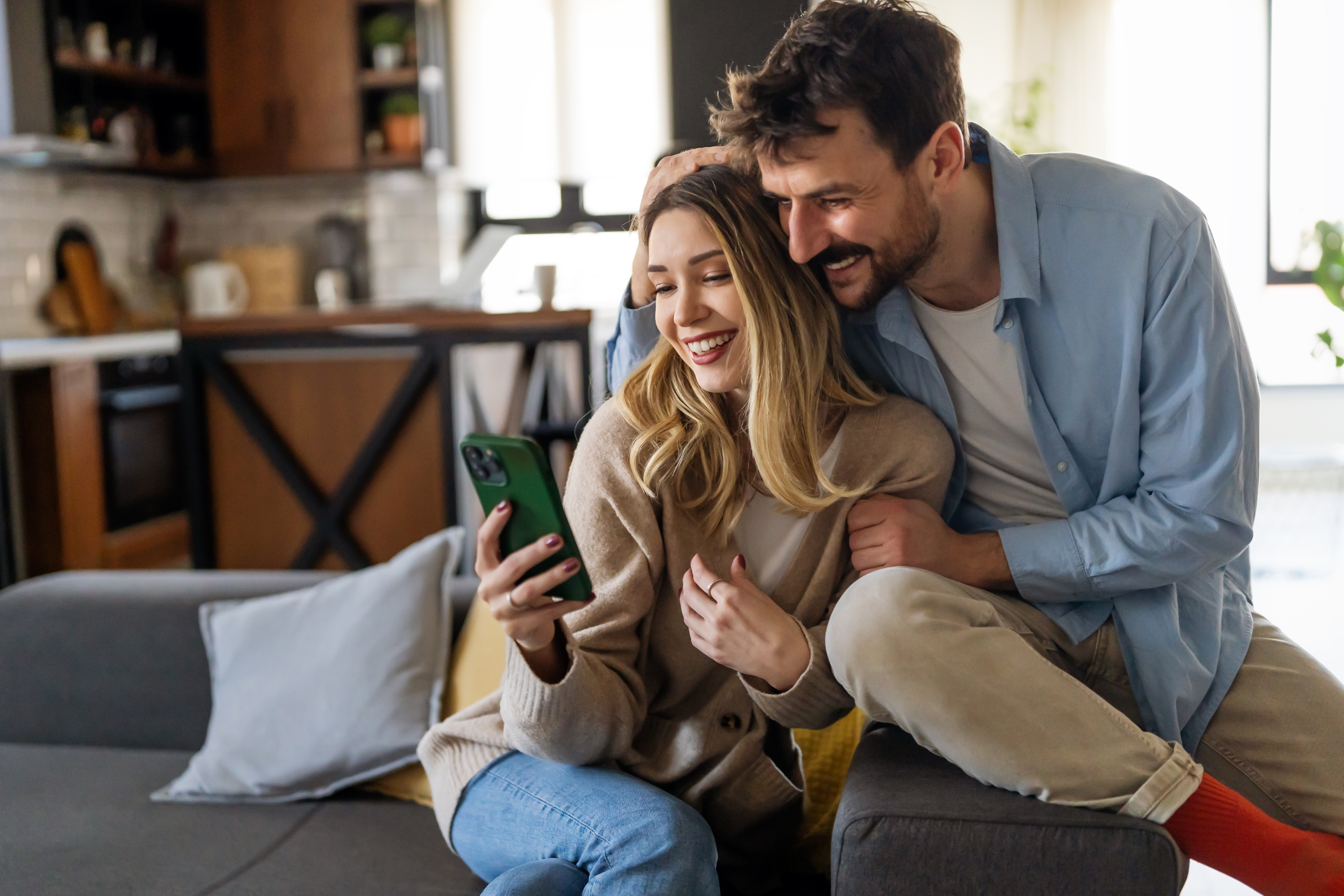 cozy couple embraces mobile phone couch home