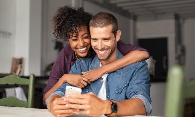 happy couple embrace dining table mobile phone