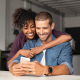 happy couple embrace dining table mobile phone