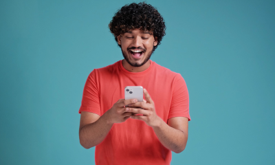 man coral shirt blue background mobile phone