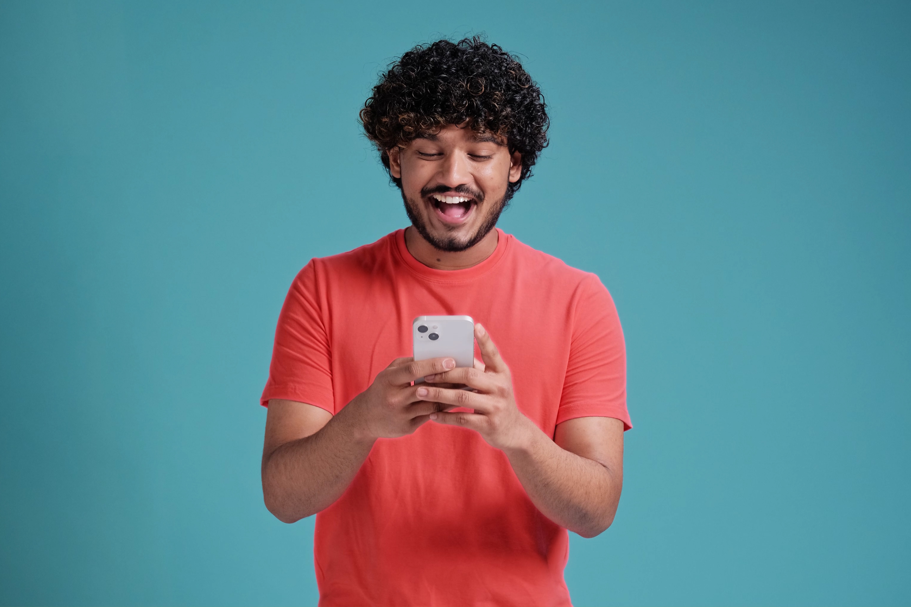 man coral shirt blue background mobile phone