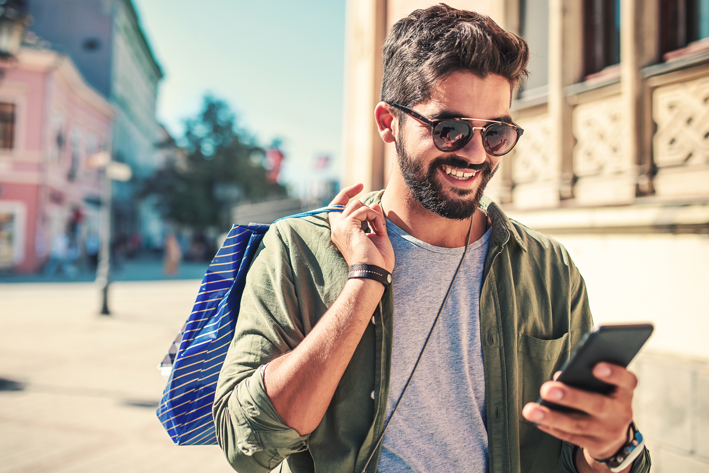 man wearing sunglasses shopping outside mobile phone