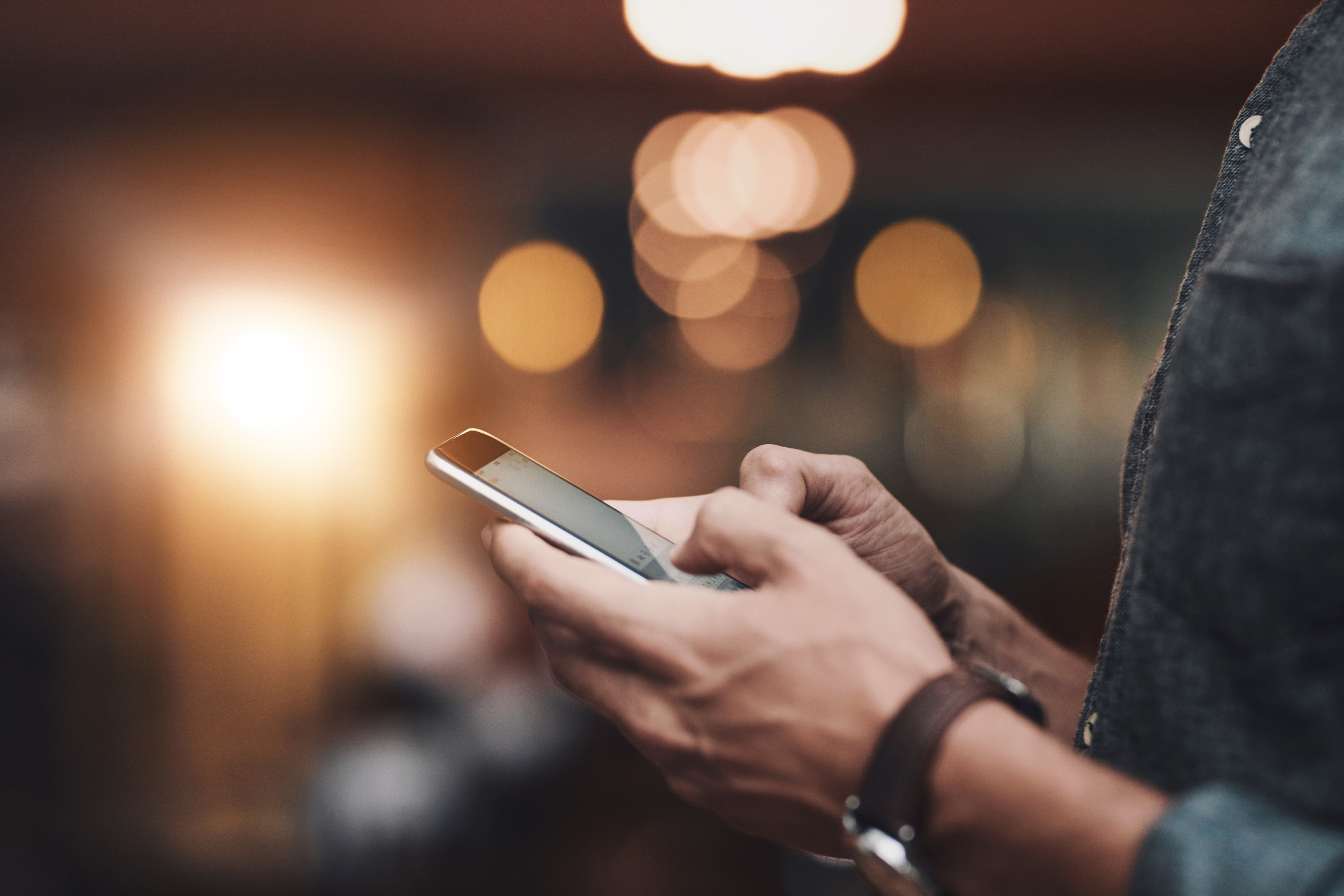 man wearing watch mobile phone blurred background