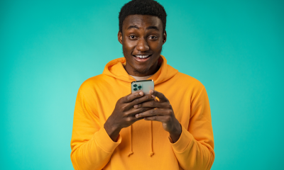 man yellow sweatshirt mint green background phone