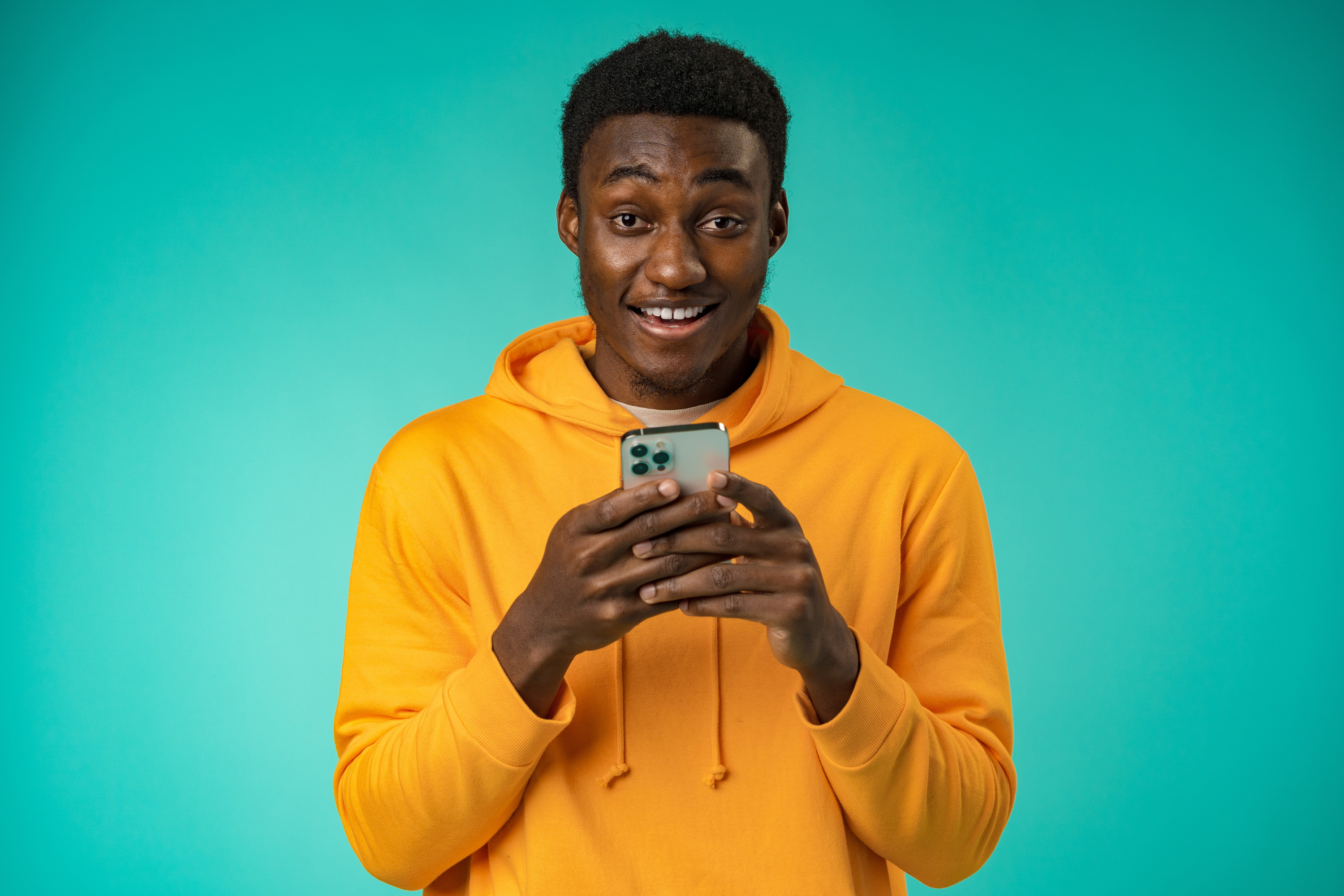 man yellow sweatshirt mint green background phone