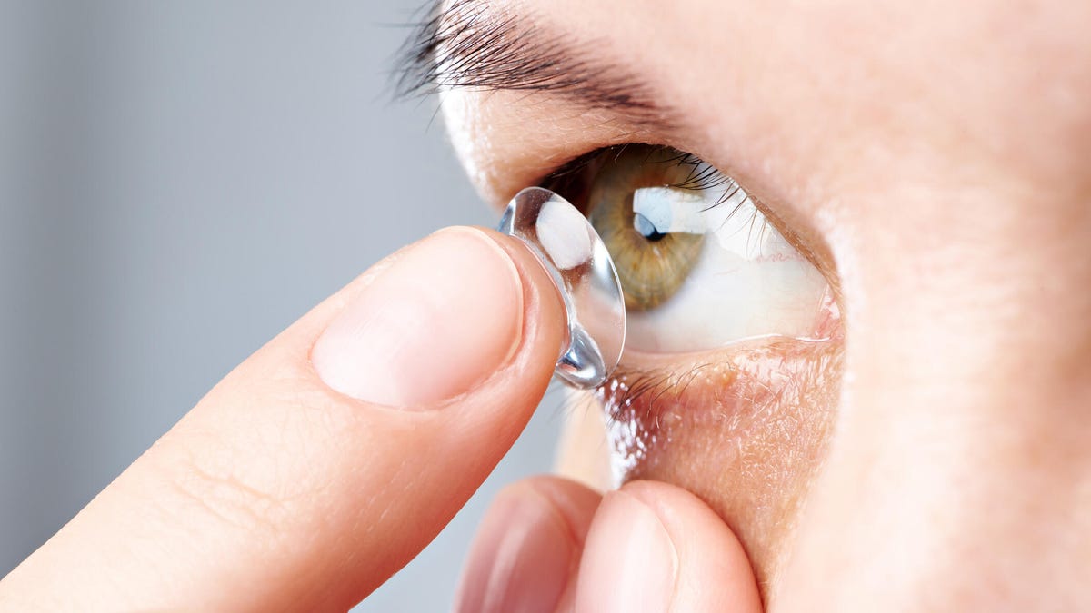 person putting in contact lens