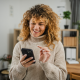 woman curly hair turtleneck sweater phone home