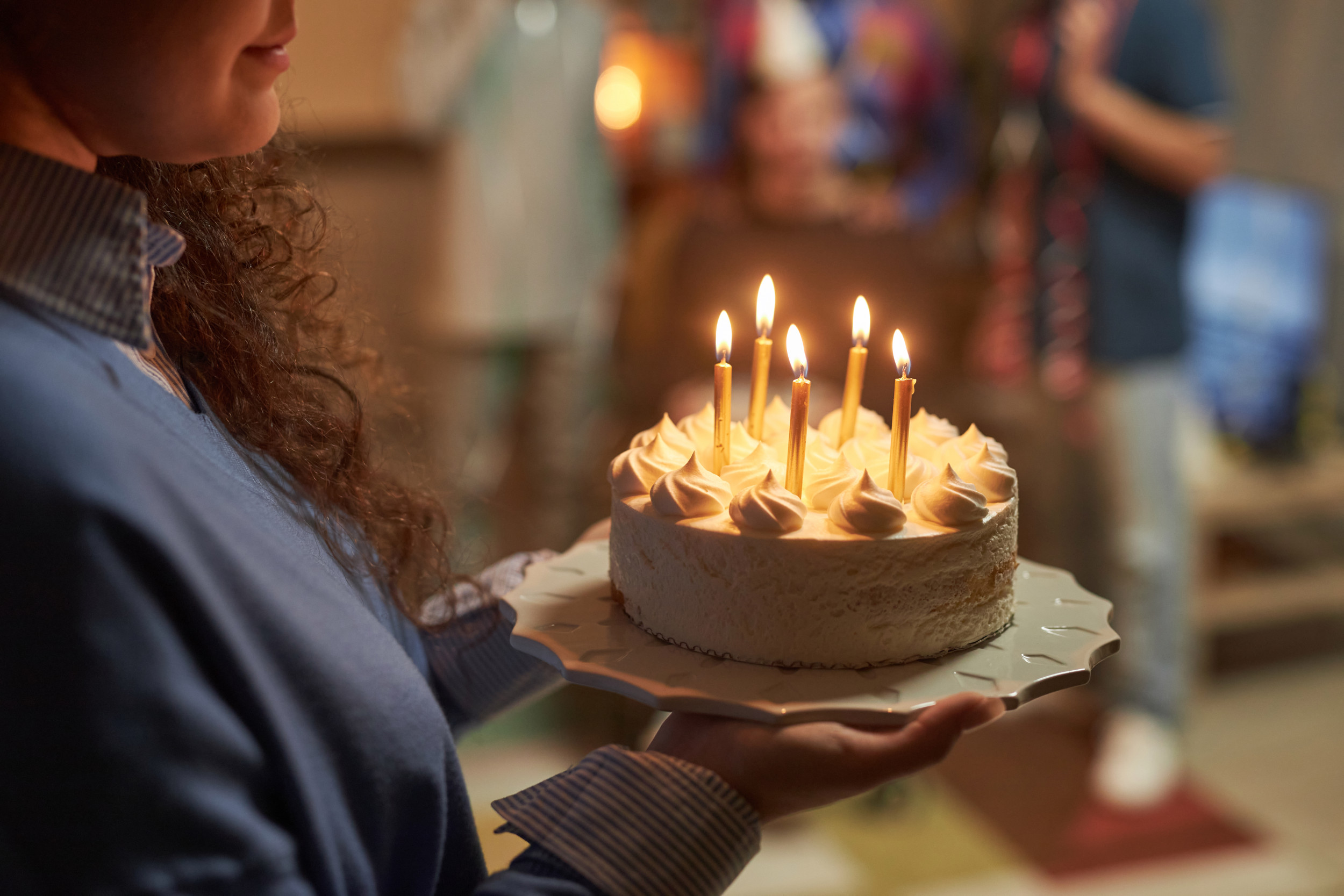 woman holds birthday cake candles