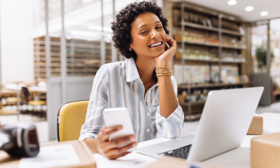 woman store owner working warehouse laptop phone