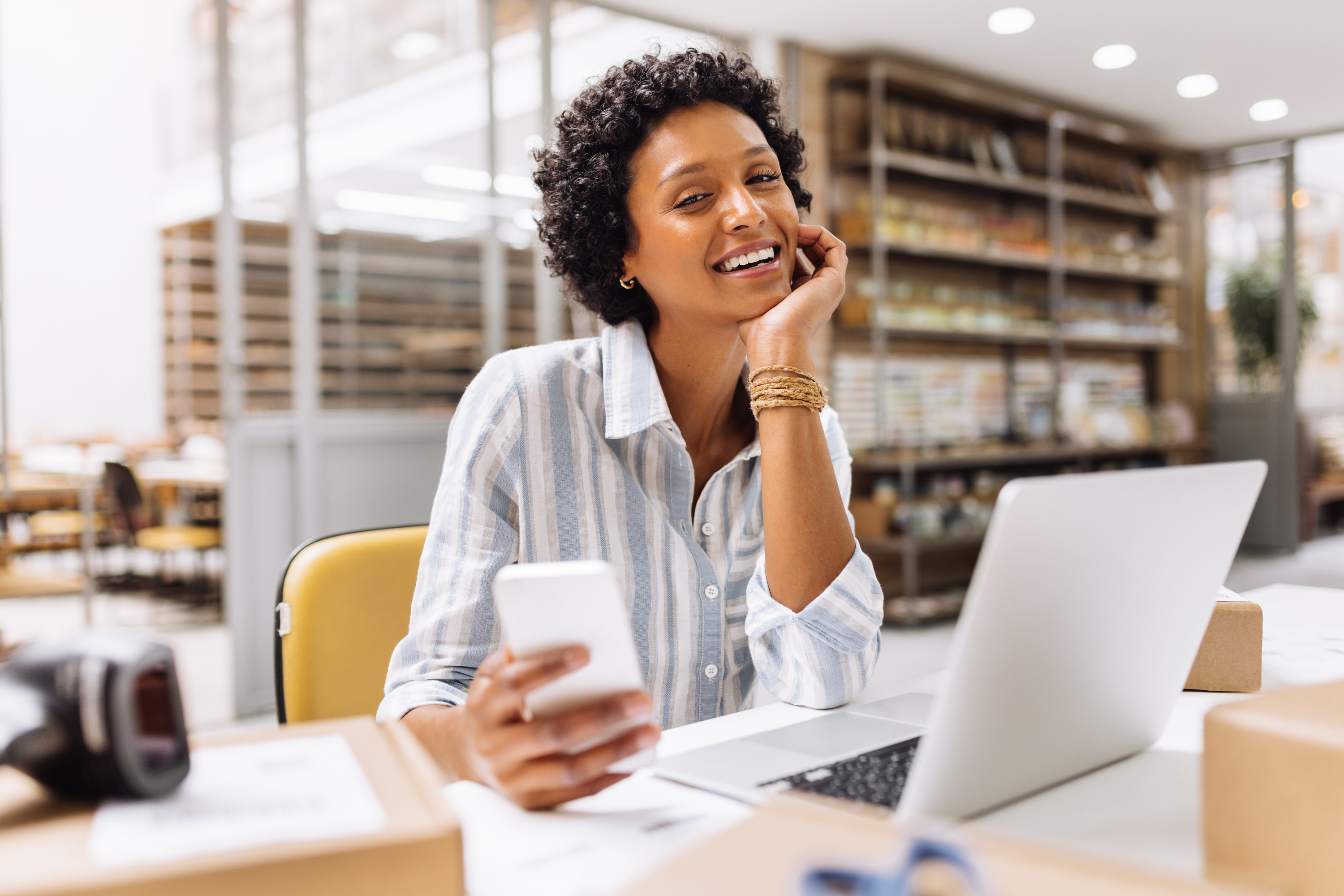 woman store owner working warehouse laptop phone