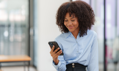 young businesswoman smiles mobile phone office building