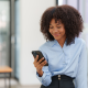 young businesswoman smiles mobile phone office building